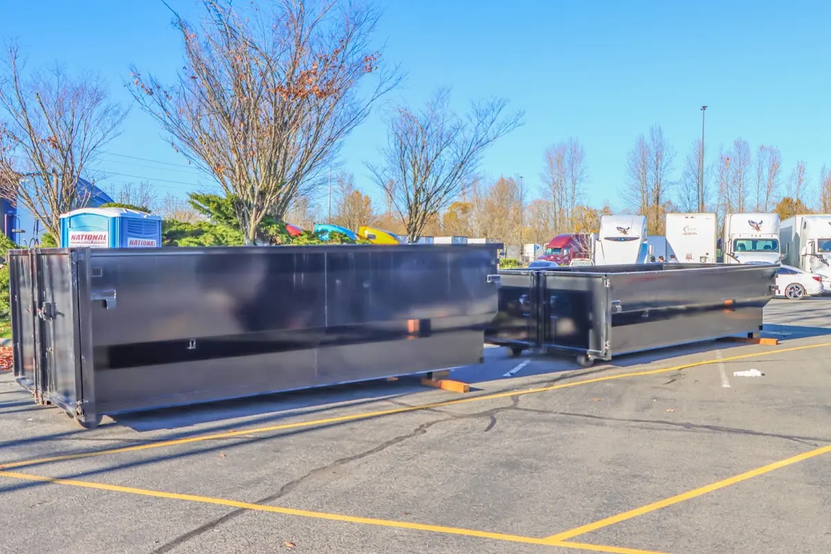 Professional dumpster rental service with roll-off container on residential driveway in Plattsburgh